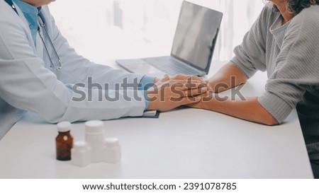 Doctor giving hope. Close up shot of young female physician leaning forward to smiling elderly lady patient holding her hand in palms. Woman caretaker in white coat supporting encouraging old person Royalty-Free Stock Photo #2391078785