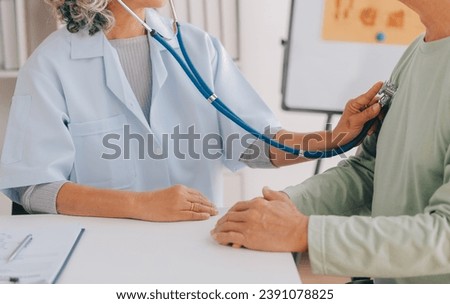 Doctor giving hope. Close up shot of young female physician leaning forward to smiling elderly lady patient holding her hand in palms. Woman caretaker in white coat supporting encouraging old person Royalty-Free Stock Photo #2391078825