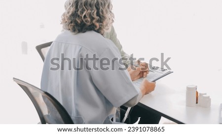 Doctor giving hope. Close up shot of young female physician leaning forward to smiling elderly lady patient holding her hand in palms. Woman caretaker in white coat supporting encouraging old person Royalty-Free Stock Photo #2391078865