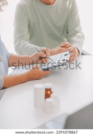 Doctor giving hope. Close up shot of young female physician leaning forward to smiling elderly lady patient holding her hand in palms. Woman caretaker in white coat supporting encouraging old person Royalty-Free Stock Photo #2391078867