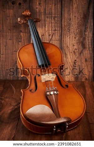 Violin, beautiful musical instrument on a rustic wooden background