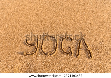 The inscription yoga on the sea sand. sea coast with yoga post with place for text