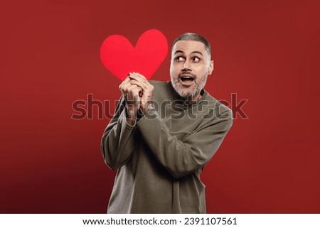 man holding a paper heart with both hands