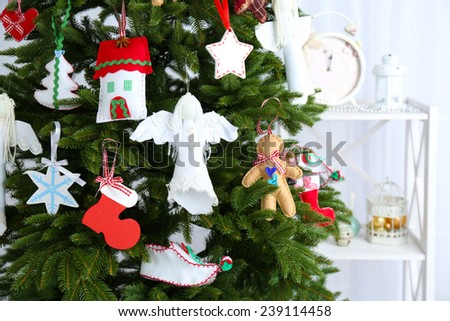 Christmas handmade decorations on Christmas tree  on light background