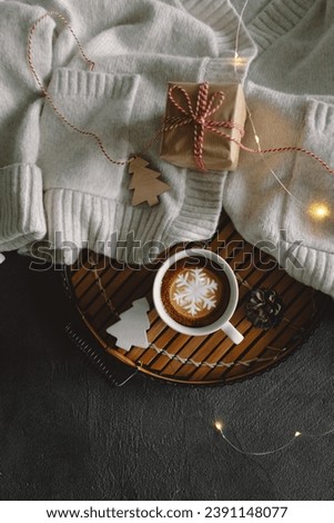 Christmas cup of coffee with sweater and Christmas decorations together with lights bokeh on a gray background. Holiday atmosphere. Winter mood, holiday decoration