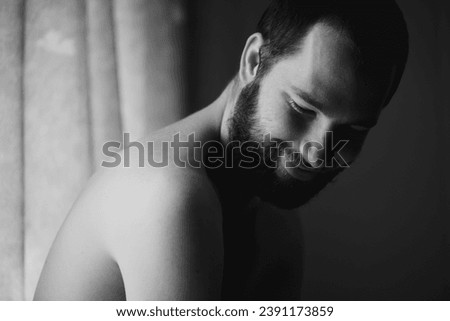 Creativity, man and smile in a bedroom at home with monochrome and black and white. Shy male person, calm thinking and art in the morning in a house with happy memory and relax with solitude