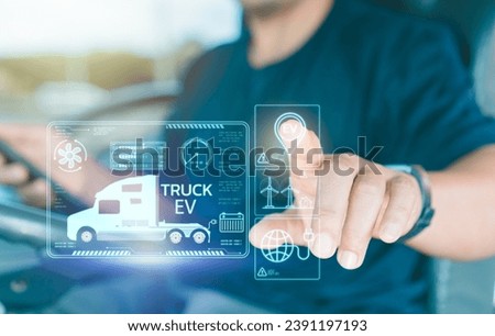 Man truck driver uses virtual screen touches to search for location Electric truck charging station for solar panels and wind turbines.Transportation and driving technology Using clean energy