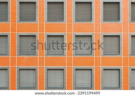 facade of a new brick building with closed windows and lowered blinds close-up.
