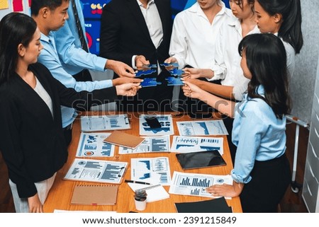 Multiethnic business people holding jigsaw pieces and merge them together as effective solution solving teamwork, shared vision and common goal combining diverse talent. Meticulous Royalty-Free Stock Photo #2391215849