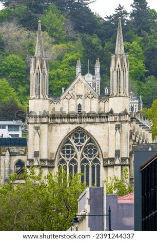 St. Paul's Cathedral in Dunedin, NZ, manifests elaborate Gothic Revival architecture with distinct spires and intricate fenestration. A prominent ecclesiastical edifice and a key historical landmark.
