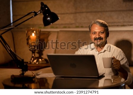 Close up of a man having coffee during late work on a computer