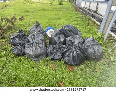Multiple Black rubbish bag  on the grass