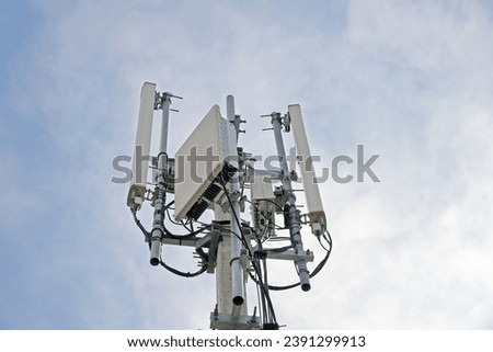 Telecommunication pole of 4G and 5G cellular. Macro Base Station. 5G radio network telecommunication equipment with radio modules and smart antennas mounted on a metal against cloulds sky background.