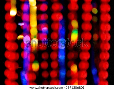 Bokeh of New Year's tinsel on a black background to create a beautiful card. Main color - red