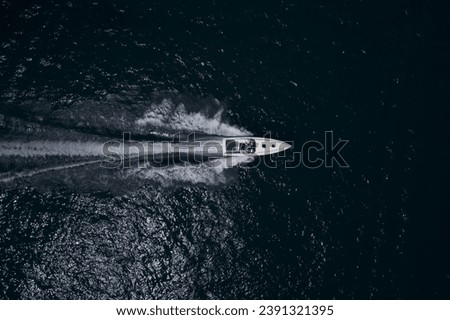 Motor boat in the sea. Travel - image. Drone view of a boat sailing. Top view of a white boat sailing to the blue sea. Royalty-Free Stock Photo #2391321395