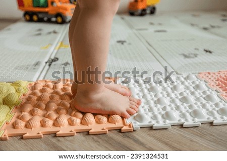 Children's bare feet, walking on an orthopedic massage mat. Prevention of flat feet in children. 