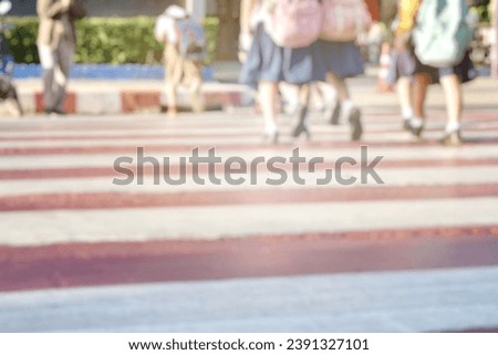 Blurry picture, Thai students in uniforms are walking across the zebra crossing to enter school in the morning.