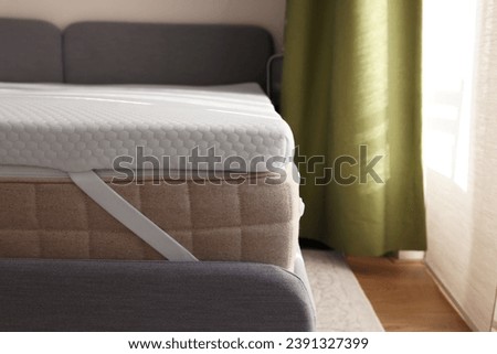 White memory foam mattress topper on grey bed indoors Royalty-Free Stock Photo #2391327399