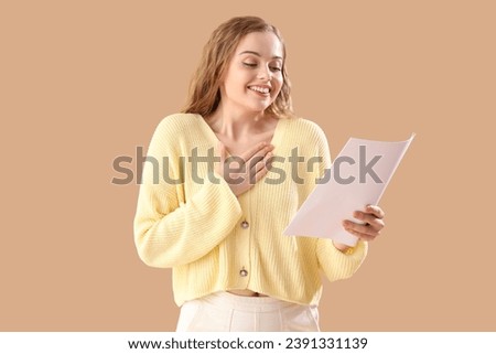 Beautiful actress with film script on beige background Royalty-Free Stock Photo #2391331139