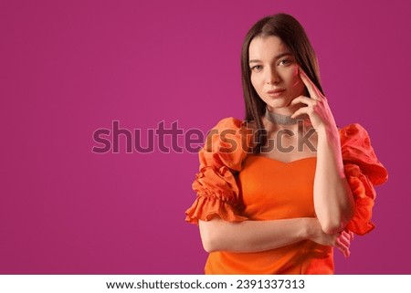 Stylish young woman on purple background