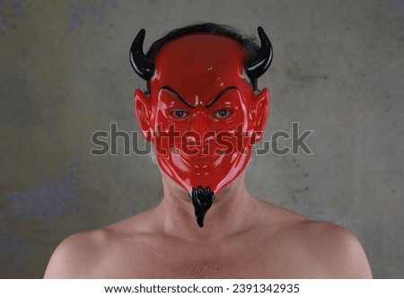 portrait of a man in a red devil mask