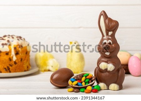 Easter chocolate bunny on a light texture table. Chocolate eggs and other sweets. Easter celebration concept. Easter sweets on the table. Place for text. copy space.