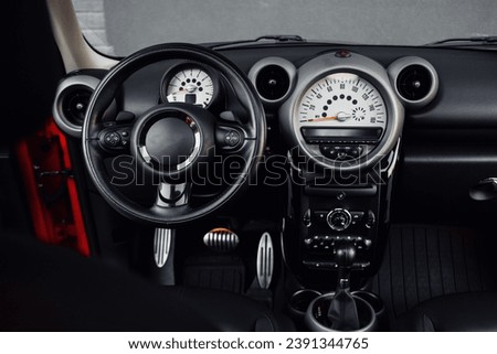 Compact, stylish and youthful crossover in bright red color. Modern black car interior.  Details interior.  Royalty-Free Stock Photo #2391344765