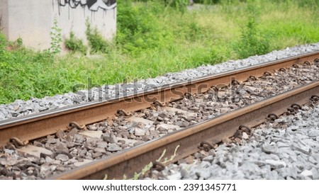 Picture of train tracks running diagonally. It is a beautiful and clear picture of a train track. which adheres to time There are medium sized rocks lined up on both sides of the road. and there is a 