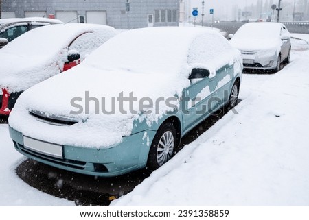 car covered with snow in winter, close-up view. Royalty-Free Stock Photo #2391358859