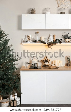 Vertical photo of kitchen modern interior with christmas tree and gifts. Room decorated for winter holidays.