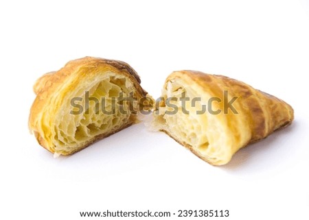 A plain croissant is cut in half, revealing a cross-section, a classic croissant from French. isolated on white background.