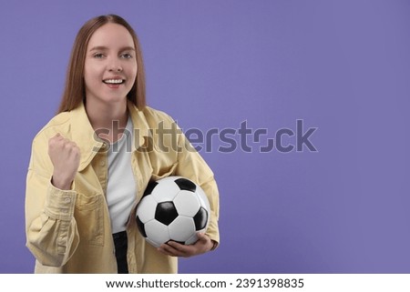 Happy sports fan with ball on purple background. Space for text