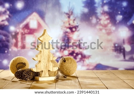 Wooden christmas tree on retro wooden table and chrismtas balls. Empty space for your decoration and blurred landscape. Mockup background for your decoration. Cold december time. New year time. 