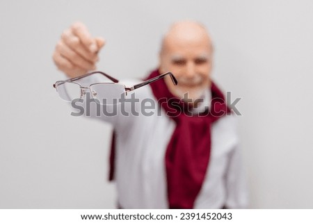 Vision correction and treatment. A mature man throws away his glasses after vision treatment. A happy man with good vision. Ophthalmic problems, poor vision in old age, macular degeneration Royalty-Free Stock Photo #2391452043