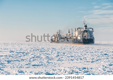 Winter shipping. Big cargo ships in frozen ice sea fairway Royalty-Free Stock Photo #2391454817