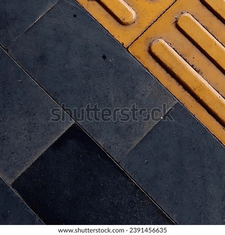 Tactile paving for the blind handicap explored, showcasing yellow braille blocks and textured tiles to create navigable pathways for the visually impaired