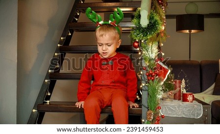 Upset toddler oy got angry on Christmas eve while waiting for Santa and gifts.