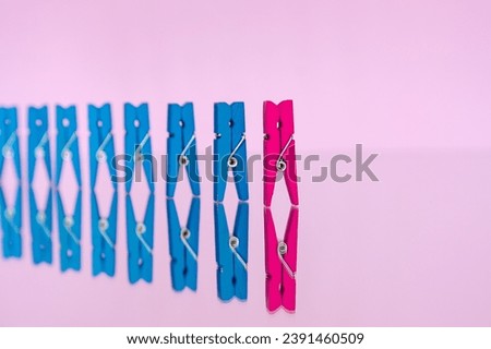 colorful wooden clothespin - abstract vision of man and woman. standing out from the crowd, leadership, difference concept. personality struggle for equality Royalty-Free Stock Photo #2391460509