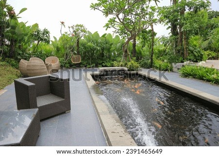 The back yard has table chairs with a view of the koi fish pond