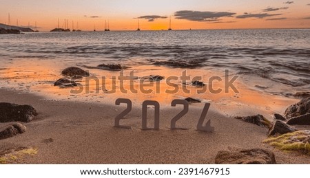 Happy New Year 2024: New Year 2024 concept with a sunset on the beach and the numbers 2024 on the sand.
