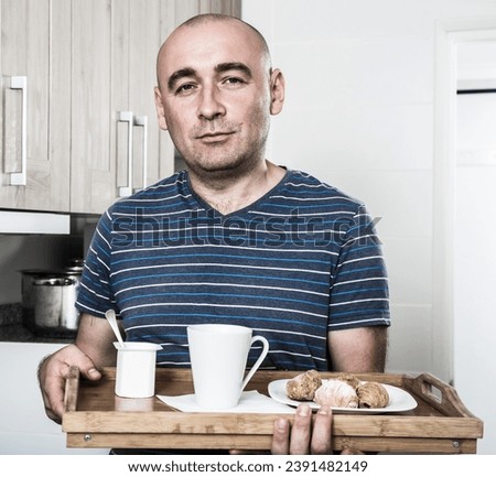 Man holding wood salver of breakfast in Royalty-Free Stock Photo #2391482149
