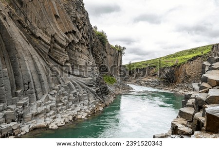 Jokla River cuts through the Studlagil canyon and passes by the hexagonal basalt columns caused by lava flows in Northeast Iceland, Jokuldalur Valley, Europe Royalty-Free Stock Photo #2391520343
