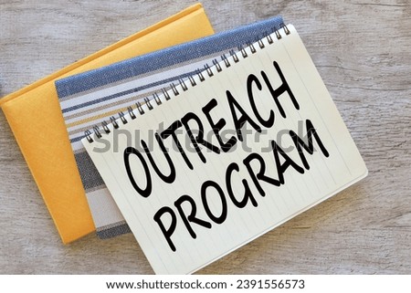 OUTREACH PROGRAM text on a page in two notepads.. Business and grant funding concept. Copy space. Royalty-Free Stock Photo #2391556573