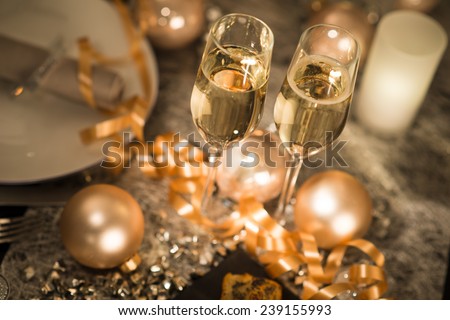 new years eve party table with champagne flute ribbon and golden glitter  Royalty-Free Stock Photo #239155993