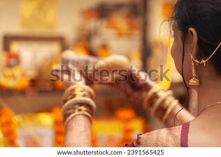 An Indian woman performing puja rituals with a plate of 'Prasadam'. Indian Hindu puja background.