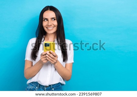 Photo of shiny dreamy lady wear white shirt communicating modern gadget looking empty space isolated blue color background