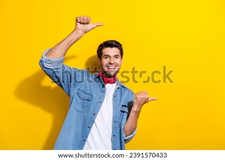 Photo portrait of attractive young man point empty space toothy smile wear trendy jeans clothes isolated on yellow color background