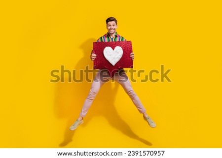 Full body size photo of funny man in air jump hold huge red symbol heart he is looking for girlfriend isolated on yellow color background
