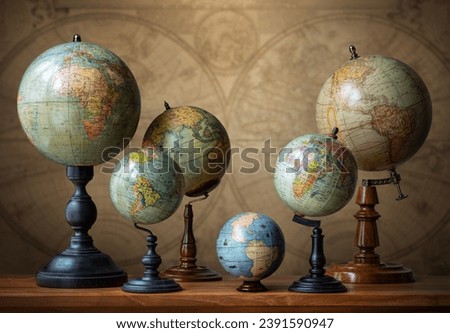 Old geographical globes on the background of a world map. Science, education, travel background. History and geography team. Ancience, antique globes collection.
