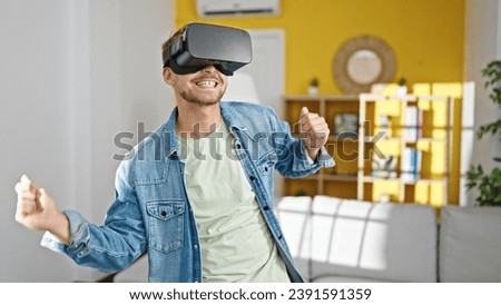 Young caucasian man using virtual reality glasses dancing at home